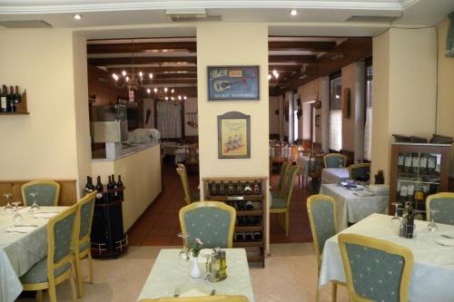 a dining room with two tables and chairs and a restaurant at Hotel Sant'Ilario in Rovereto