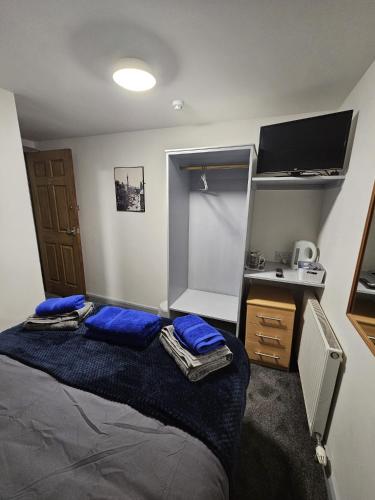 a bedroom with a bed with blue pillows and a desk at Black Bull in Wylam