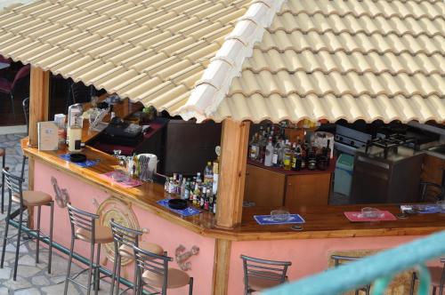 a bar in a restaurant with a wooden counter and chairs at Maria Studios in Paleokastritsa