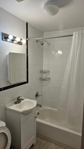 a white bathroom with a sink and a shower at Lamartine Chelsea in New York