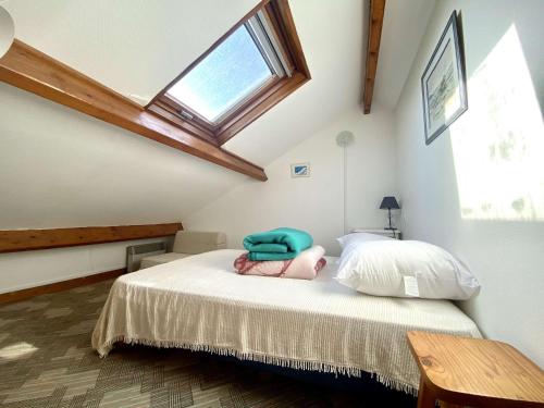 a bedroom with a bed and a skylight at REF 033 Appartement T3 vue mer Les Terrasses de Kerjouanno Arzon in Arzon