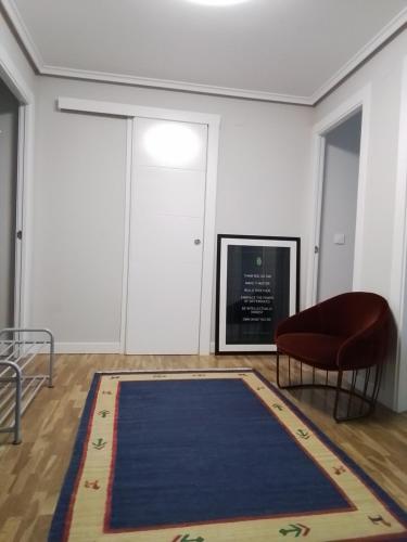 a room with a blue rug and a chair and a door at Salimar 23 in Salinas