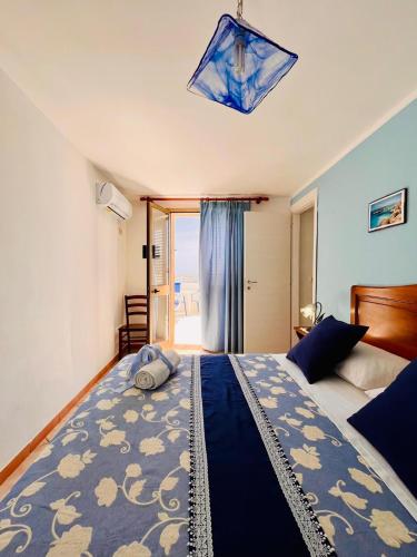 a bedroom with a large bed with a blue blanket at Hotel Giglio in Lampedusa