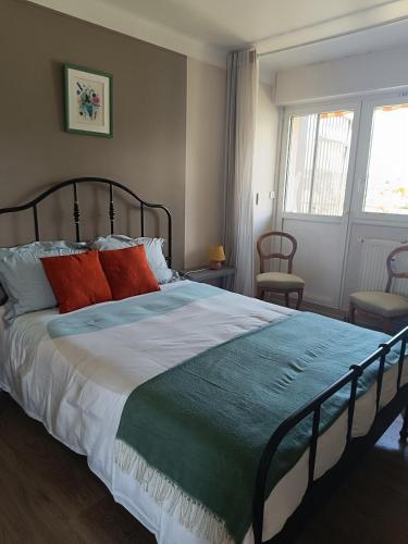 une chambre avec un grand lit avec des oreillers rouges dans l'établissement La Tour Gambetta T3 Vue lac, à Annecy