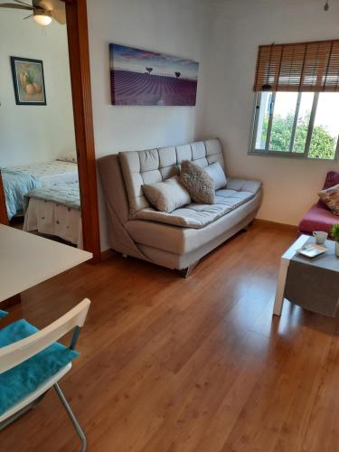 a living room with a couch and a table at Apto a 2 minutos de playa. in Fuengirola