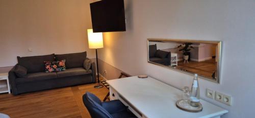 a living room with a couch and a mirror at Schlosshotel Hohenbocka in Hohenbocka