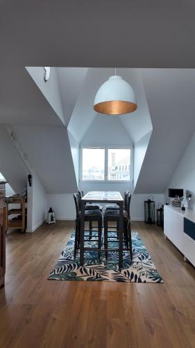 une salle à manger avec une table et des chaises sur un tapis dans l'établissement **La Bretonnerie, bel appartement de standing, à Concarneau