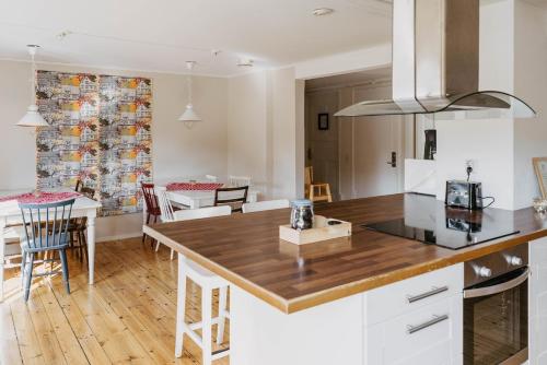 a kitchen and dining room with white cabinets and a table at Ödevata Gårdshotell in Emmaboda