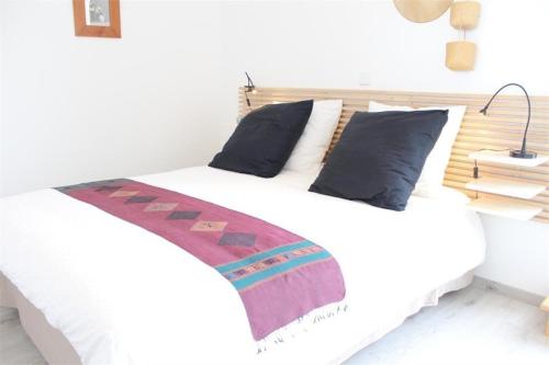 une chambre avec un lit blanc avec des oreillers bleus dans l'établissement Appt 3 pièces LA ROCHELLE - LR360-307, à La Rochelle