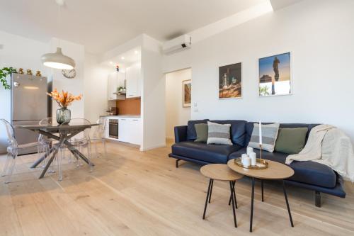 uma sala de estar com um sofá azul e uma mesa em Skyline Rooftop Suite - Milano Isola District - New Collection em Milão