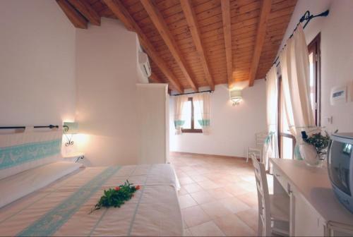 a dining room with a table with flowers on it at Relaxing Residence Baia dei Mirti Studio M3-3 persons-Unit 2 in Vignola Mare
