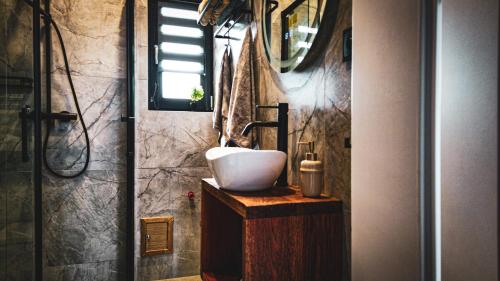 a bathroom with a white sink on a wooden counter at Stodoła nad wodą in Olecko Małe