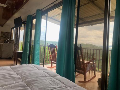 a bedroom with a bed and a balcony with a view at Conectar con la naturaleza in Esparza