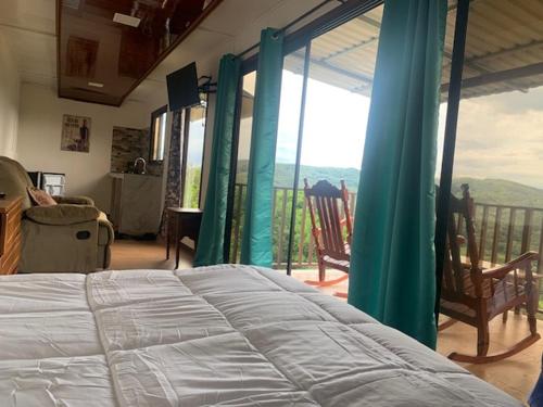 a bedroom with a bed and a balcony with a view at Conectar con la naturaleza in Esparza