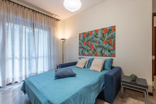 Un dormitorio con una cama azul con una pintura en la pared en Rapallo-Portofino, Chic and Cozy apt with pool, en Rapallo