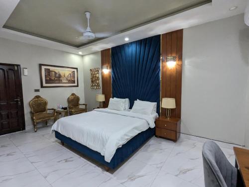 a bedroom with a large bed with a blue curtain at Grand Fort Boutique Hotel Dha in Karachi