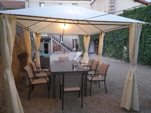 une table et des chaises sous un parasol blanc dans l'établissement Ils en ont rêvé, à Chambon-le-Château
