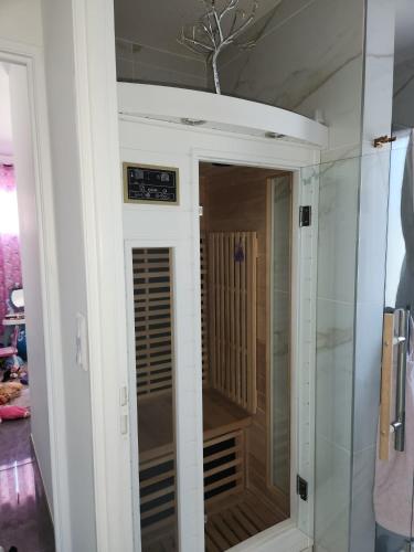 - une douche dans une chambre avec une porte en verre dans l'établissement Villa avec piscine jacuzzi et sauna, à Saint-André-de-Cubzac