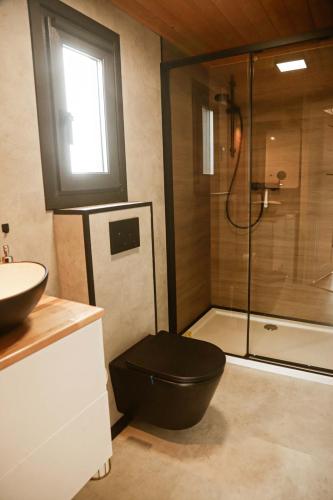 a bathroom with a black toilet and a shower at Black & White Cekcyn Bory Tucholskie in Cekcyn