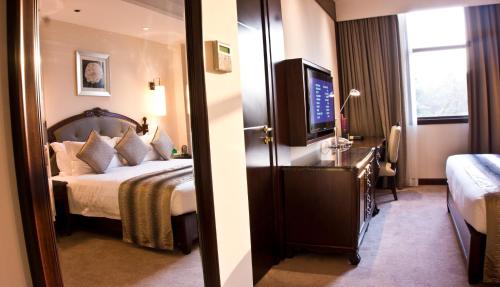 een hotelkamer met een bed en een televisie bij Tang Palace Hotel in Accra