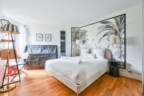 une chambre avec un grand lit blanc et une chaise dans l'établissement GuestReady - Charming stay near Catacombs of Paris, à Paris