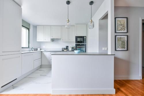 - une cuisine blanche avec des placards blancs et un comptoir dans l'établissement GuestReady - Charming stay near Catacombs of Paris, à Paris