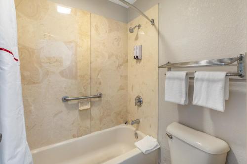 a bathroom with a tub and a toilet and a sink at Red Roof Inn Ft Pierce in Fort Pierce