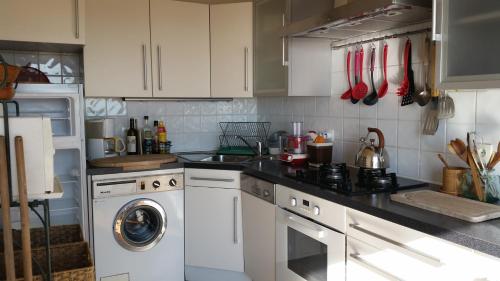 une cuisine avec des armoires blanches et une machine à laver dans l'établissement Cannes Penthouse, à Cannes