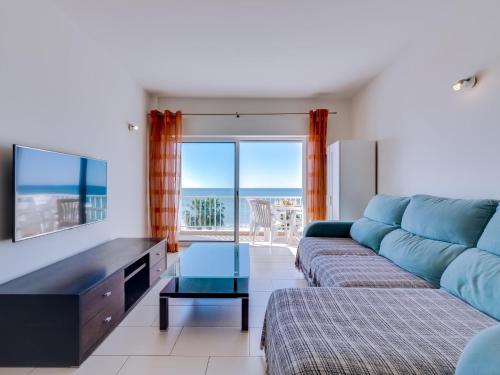 a living room with a couch and a view of the ocean at Canto do Mar in Quarteira
