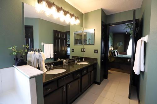 a bathroom with two sinks and a large mirror at Waterfront 6-Bedroom Wizarding Villa in Lake Berkley Near Universal Studio's Harry Potter in Kissimmee