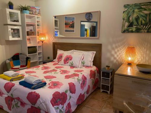 a bedroom with a bed with a floral comforter at Meublé tourisme Carmes 2 étoiles, entrée autonome,wifi, climatisé, petit parking privé in Toulouse