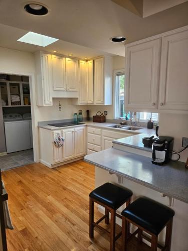 a kitchen with white cabinets and a wooden floor at Hot Tub 3 Kings Close To Everything in Bloomington