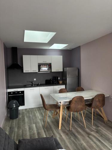 une cuisine avec une table et des chaises dans une pièce dans l'établissement Villa la Garenne idéale pour les familles, plage : Bréhat, à La Bernerie-en-Retz