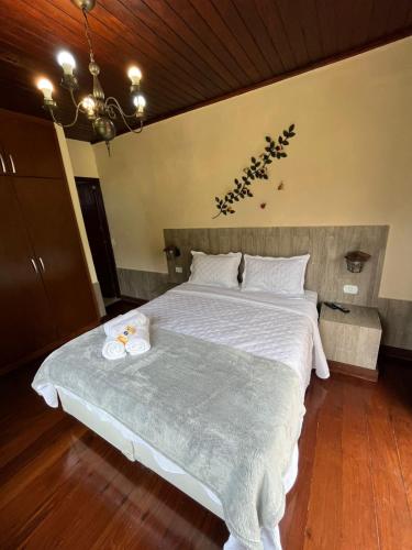 a bedroom with a large bed with white sheets at Recanto dos Vianas in Teresópolis