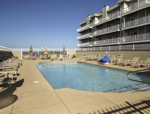a swimming pool with lounge chairs and a hotel at LUC 2Bed Bayside Condo in Ocean City