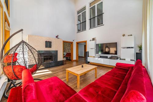 a living room with a red couch and a tv at Amber Villa in Rīga