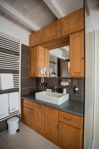 a bathroom with a sink and a mirror at Olimpia Hotel in Bormio