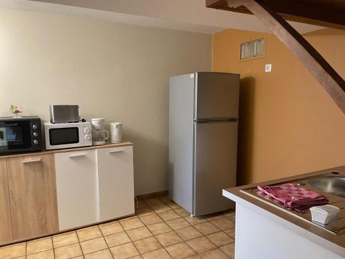 une cuisine avec un réfrigérateur et un micro-ondes dans l'établissement Apartment 54m2 1er étage, à Montfort-le-Gesnois