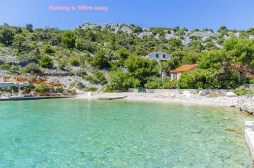Blick auf einen Fluss mit einem Haus im Hintergrund in der Unterkunft Apartments Otjana in Sevid