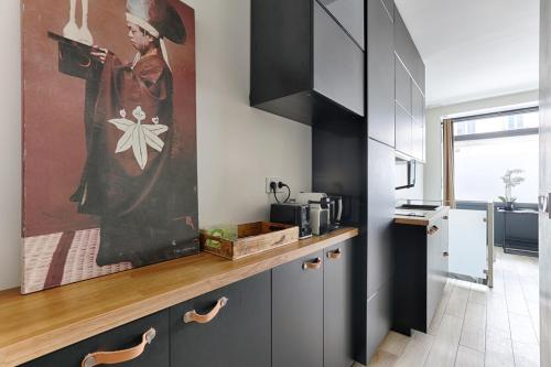 une cuisine avec une peinture d'une femme sur le mur dans l'établissement Paris Montmartre Sacré Cœur Superb Duplex, à Paris