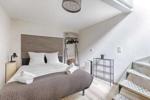 une chambre blanche avec un grand lit avec des oreillers blancs dans l'établissement Paris Montmartre Sacré Cœur Superb Duplex, à Paris