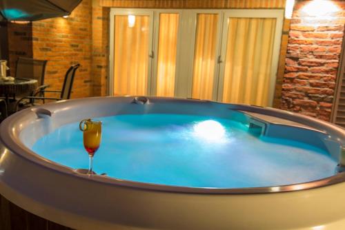 uma banheira de hidromassagem com um copo de vinho em Hotel Villa Morra Residence em Assunção