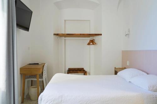 a bedroom with a bed and a tv and a desk at Sud Hôtel Restaurant in Bastia