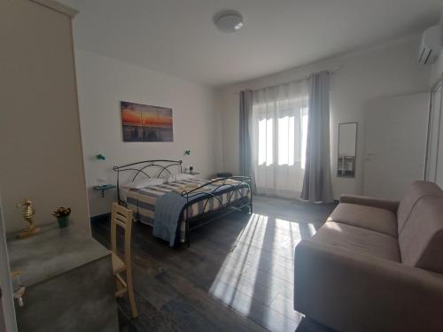 a bedroom with a bed and a couch at Porto Sicuro Hospitality in Cagliari