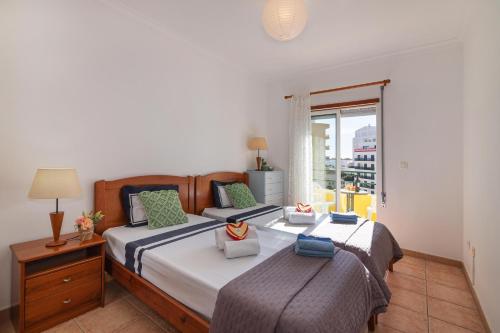 a bedroom with two beds and a window at Rocha Retreat - Praia Da Rocha in Portimão