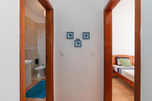 a bathroom with a mirror and a bed in a room at Rocha Retreat - Praia Da Rocha in Portimão