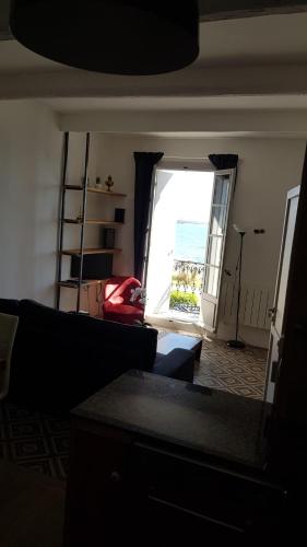 un salon avec un canapé et une grande fenêtre dans l'établissement La petite Maison, à Bouzigues