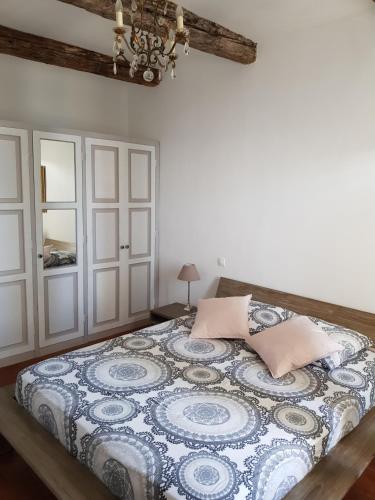 une chambre avec un lit avec une couette bleue et blanche dans l'établissement La petite Maison, à Bouzigues