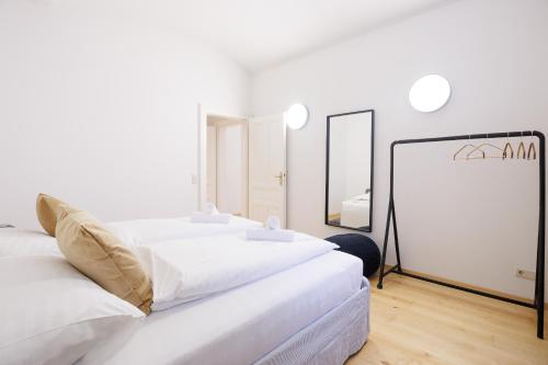 a white room with two beds and a mirror at Belvedere City Apartment in Vienna