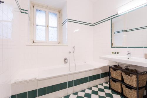 a bathroom with a tub and a sink at Belvedere City Apartment in Vienna